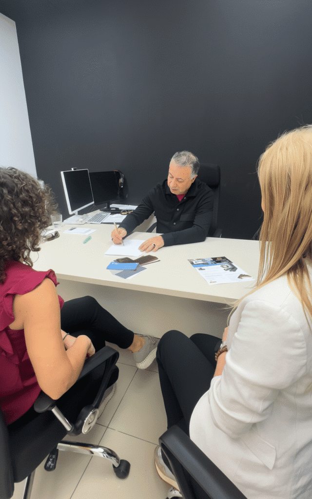 reunión de negocios en oficina hombre firmando documentos con dos mujeres asesoría financiera o automotriz