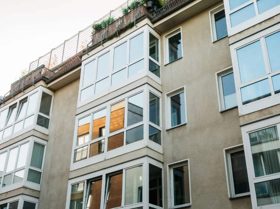 Fachada de edificio moderno en Madrid con grandes ventanas PVC y balcones acristalados para el aislamiento térmico.